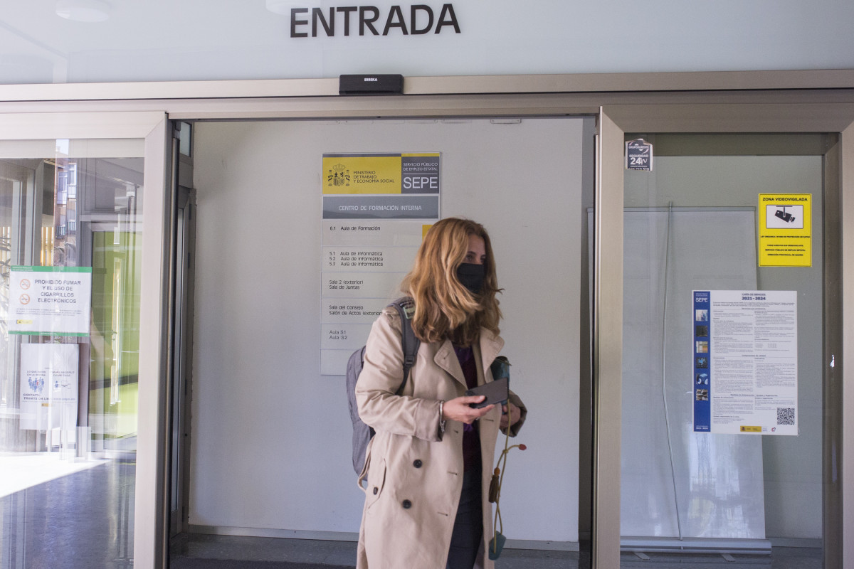 Una dona entra per la porta d'una oficina de l'SEPE el dia en què s'han conegut les dades d'atur de març, a 6 d'abril de 2021, a Madrid (Espanya). El nombre d'aturats registrats a les oficines dels serveis públics d'ocupació (antic Inem