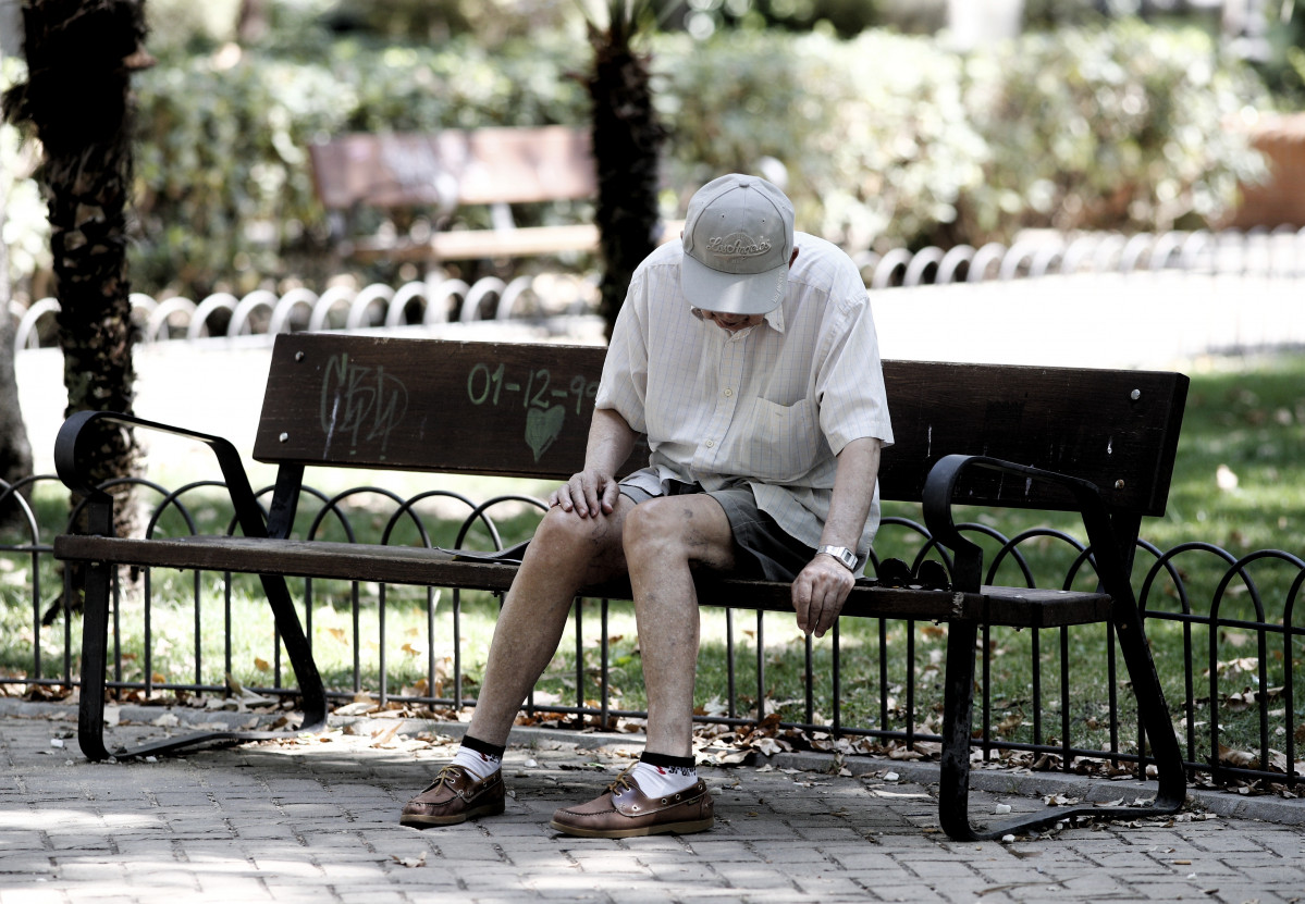 Arxiu - Un pensionista descansa en un banc d'un parc de Madrid.