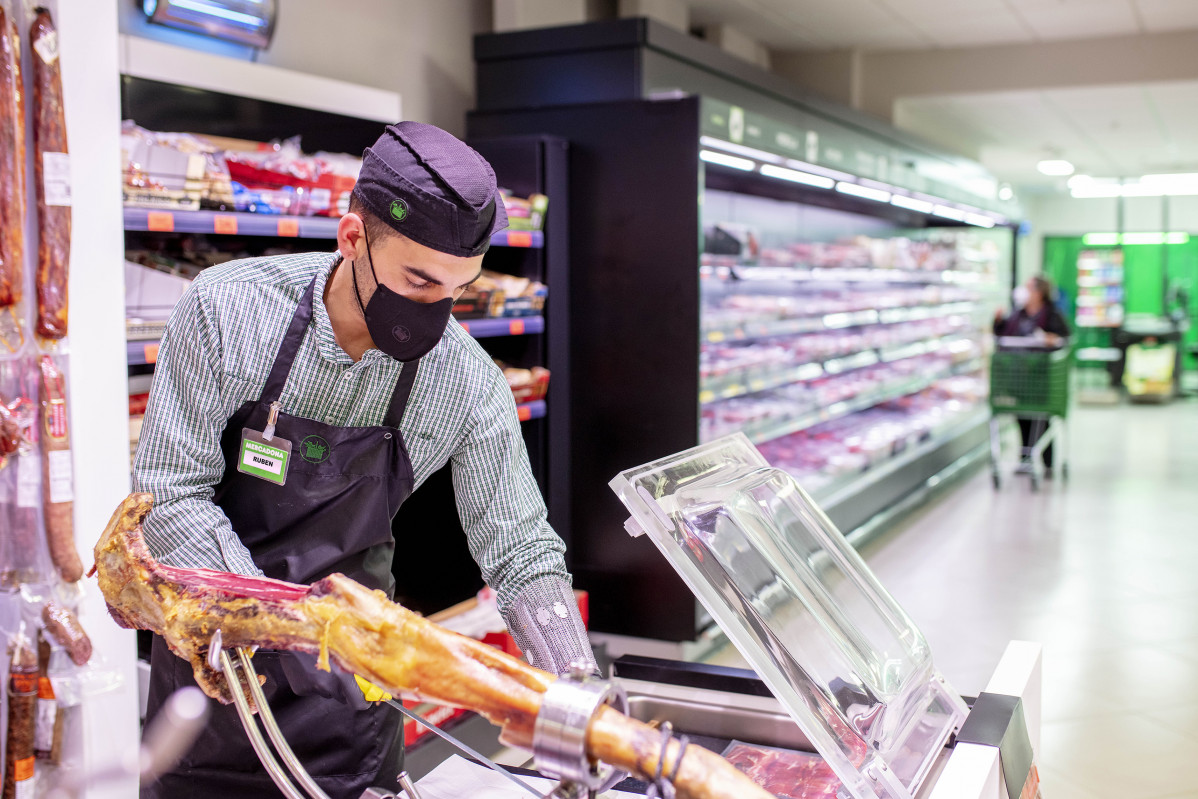 FOTOGRAFIA Rubu00e9n, Treballador de l'supermercat de Sagrada Famu00edlia a Barcelona ciutat, amb la nova mascareta corporativa