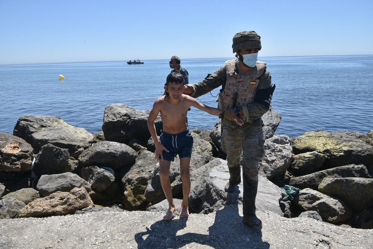 Un militar de l'exèrcit espanyol ajuda a un menor migrant procedent del Marroc a la seva arribada a Ceuta, a 19 de maig de 2021, a Ceuta, (Espanya). Els intents d'arribar a Ceuta no han cessat des de dilluns i passades 72 hores el balanç de migrants que ha