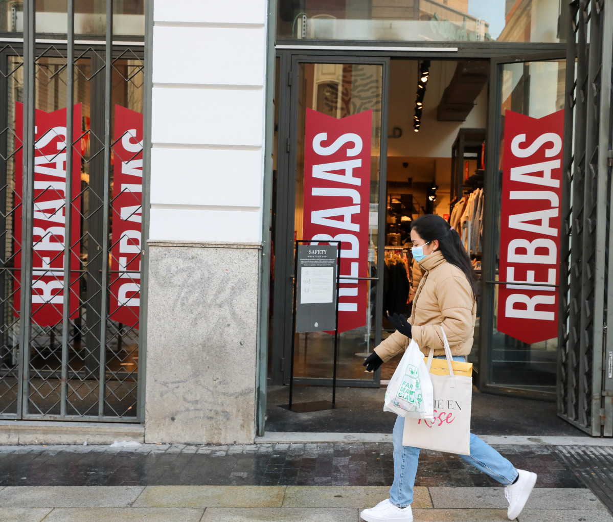 Arxiu - Una dona passa per davant d'un establiment en rebaixes