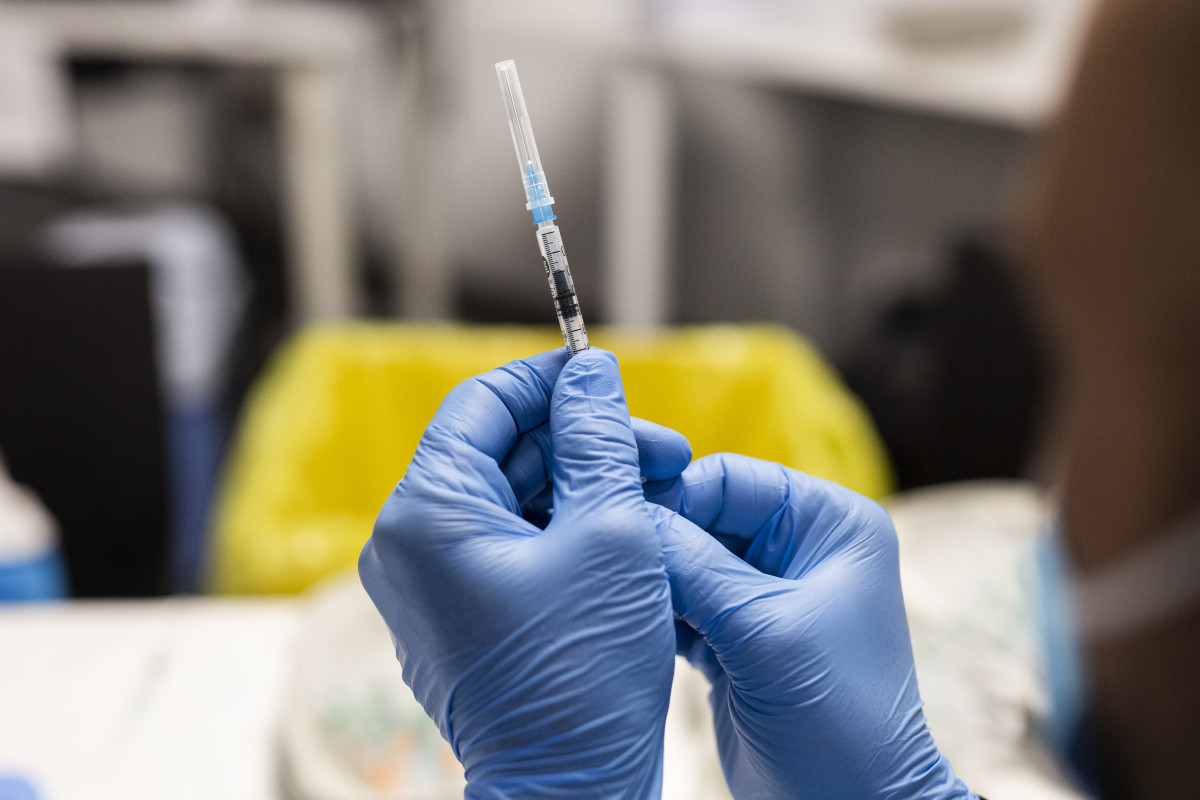 Un sanitario sostiene una dosis de la vacuna de Pfizer
