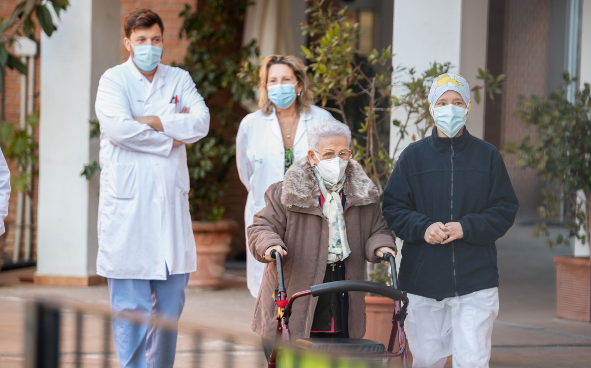 L'Araceli i la Mònica, la resident més longeva de la Residència de majors Los Olmos i la sanitària més jove, acompanyades de personal de l'geriàtric, després de rebre la segona dosi de la vacuna Pfizer-BioNTech, a Guadalajara, Castella-la Manxa.