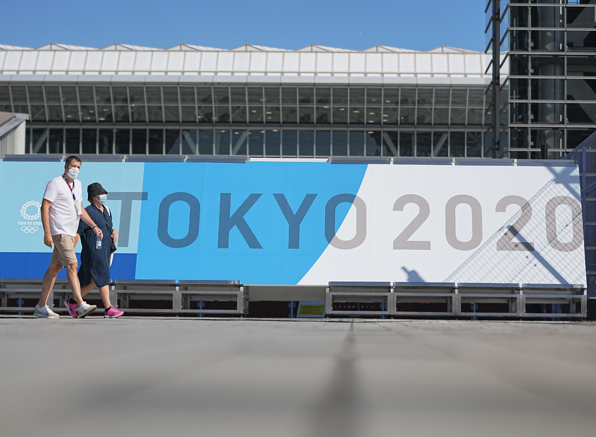 Ciutadans al Japó caminen al costat d'un cartell dels Jocs Olímpics de Tòquio 2020