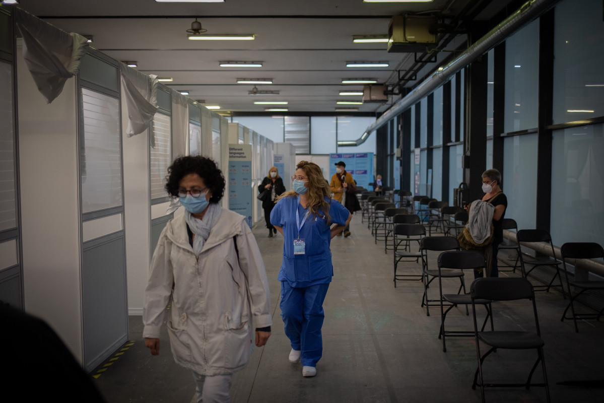 Archivo - Una mujer y una sanitaria en el circuito de vacunación de Fira de Barcelona, a 26 de abril de 2021, en Barcelona, Cataluña (España). El circuito de vacunación es una prueba piloto de vacunación para futuras inoculaciones a gran escala cuando lle