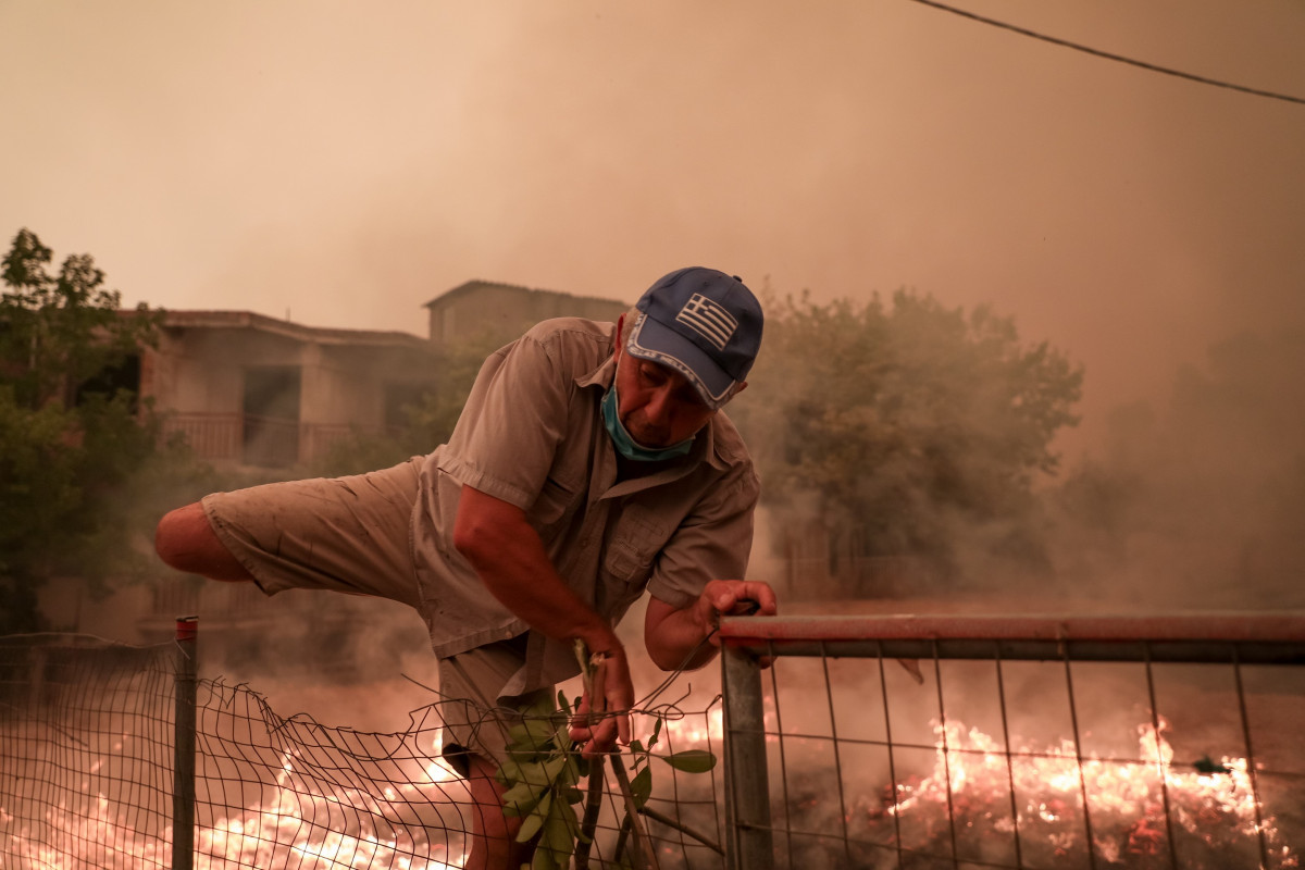 EuropaPress 3876706 08 august 2021 greece Pefki man climbs over fence to escapament the flames
