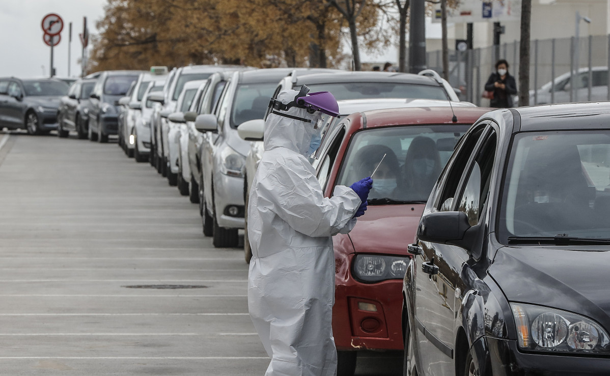 Arxiu - Un sanitari realitza una prova PCR a una persona des del seu vehicle per a la detecció de l'coronavirus.
