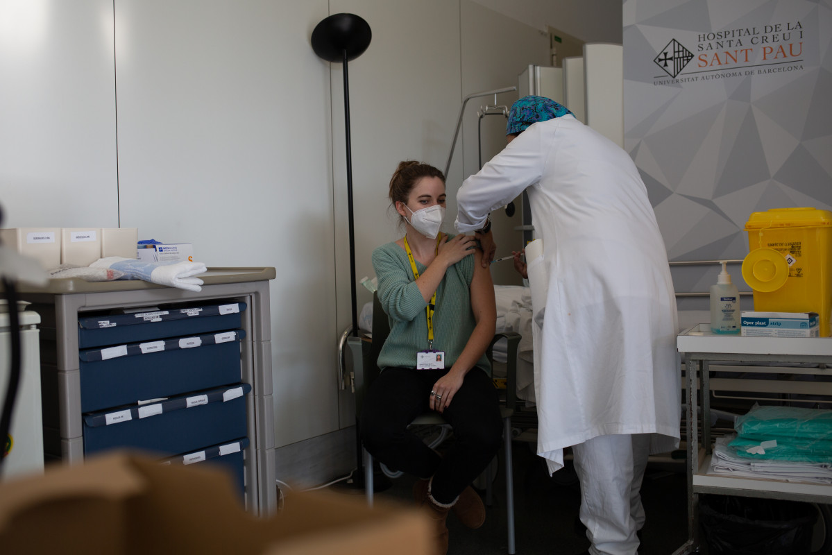 Archivo - Una enfermera vacuna a un profesional sanitario con la vacuna de Pfizer-BioNtech contra el COVID-19 en el Hospital de la Santa Creu i Sant Pau de Barcelona.