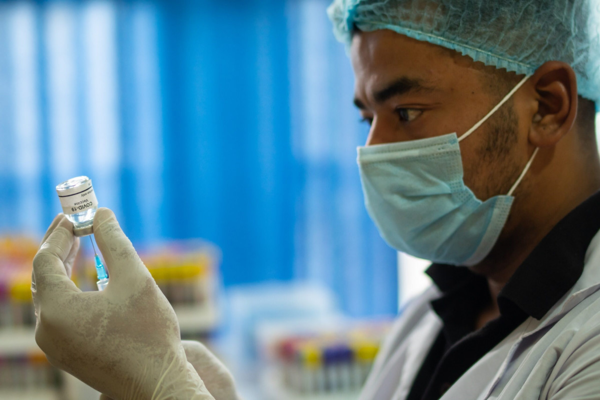 Un metge manipulant una vacuna del coronavirus