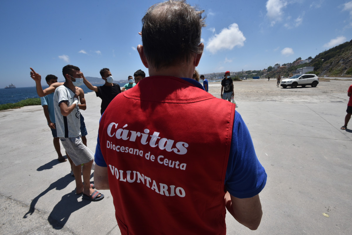 Arxiu - Un treballador de Càritas Diocesana reparteix aliments a migrants que van entrar a Ceuta.