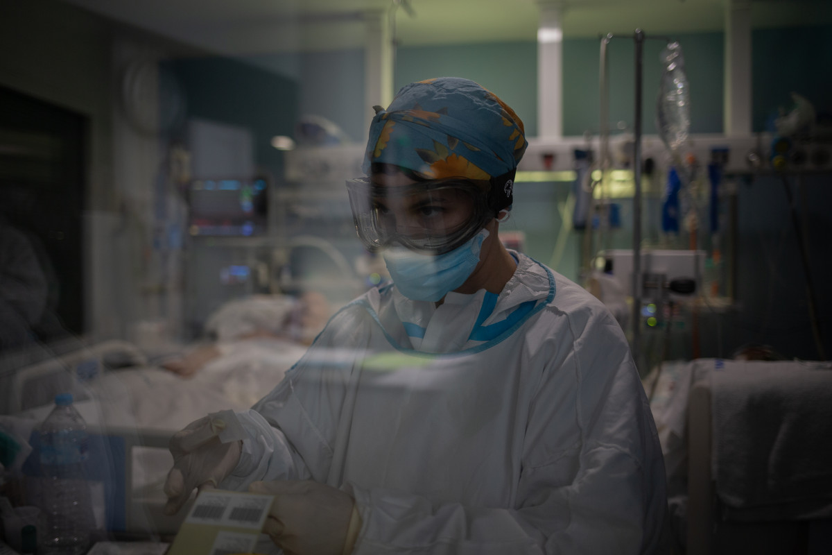 Archivo - Un trabajador sanitario protegido en una UCI