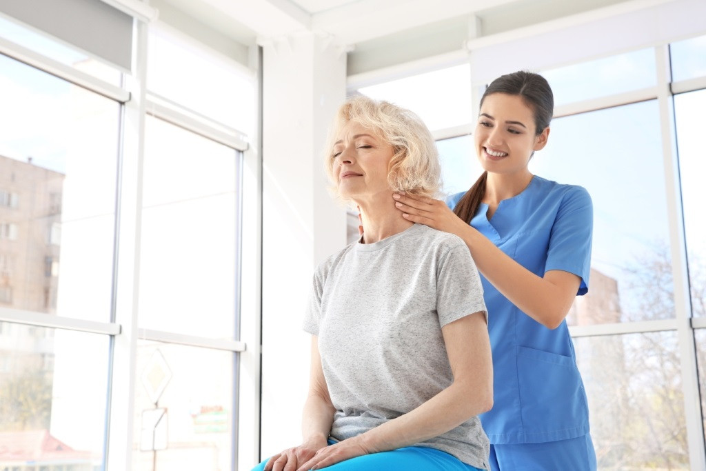 Fitxer - Dona major rebent assistència per una fisioterapeuta.