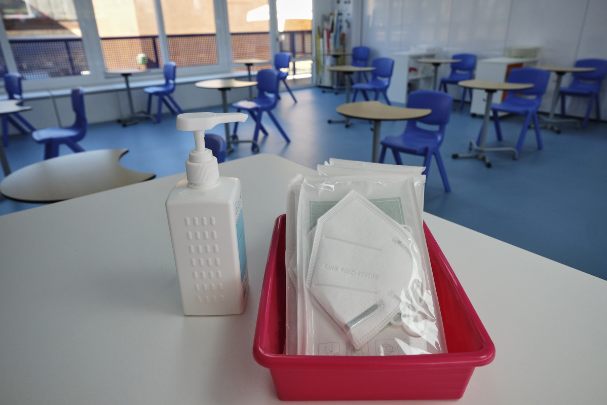 Arxiu - Mascaretes i gel desinfectant a la taula del professor d'una aula (arxiu)