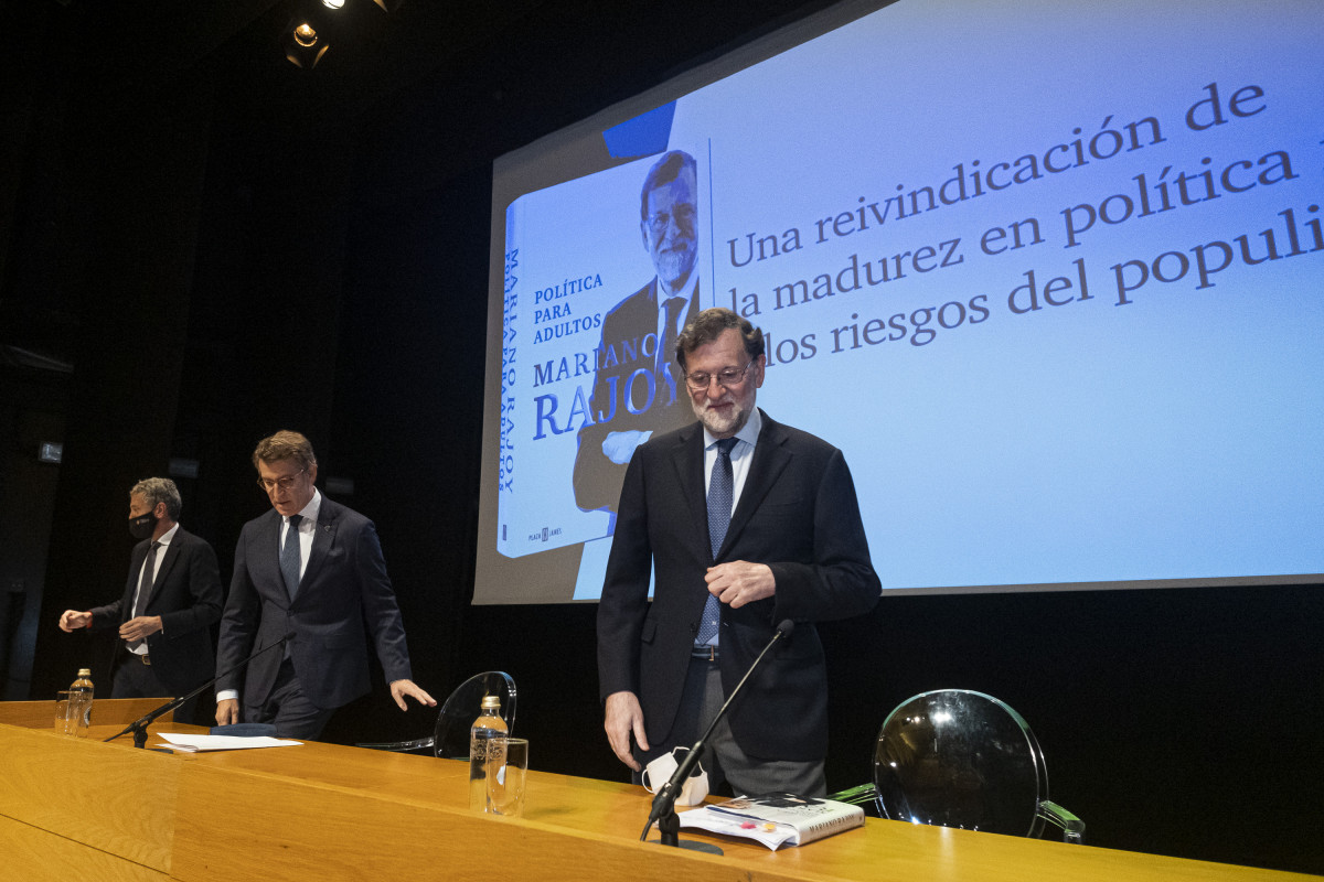 L'expresident del Govern Mariano Rajoy (d) i el president de la Xunta de Galícia Alberto Núñez Feijóo (c), a la presentació del llibre ‘Política per a adults’. a l'Auditori Abanca, a 3 de desembre de 2021.