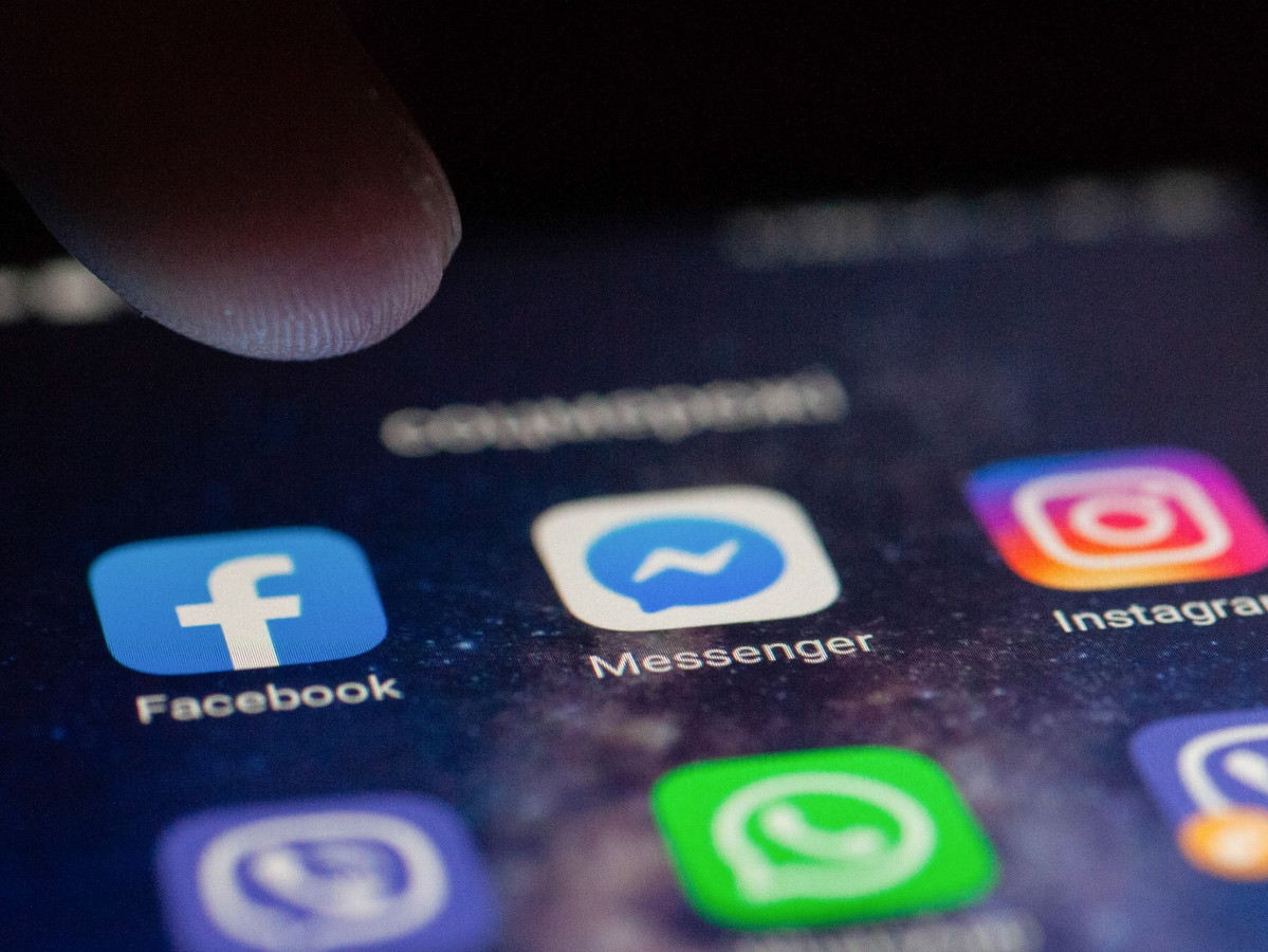 In this photo illustration, finger touching the Facebook application on smartphone screen.