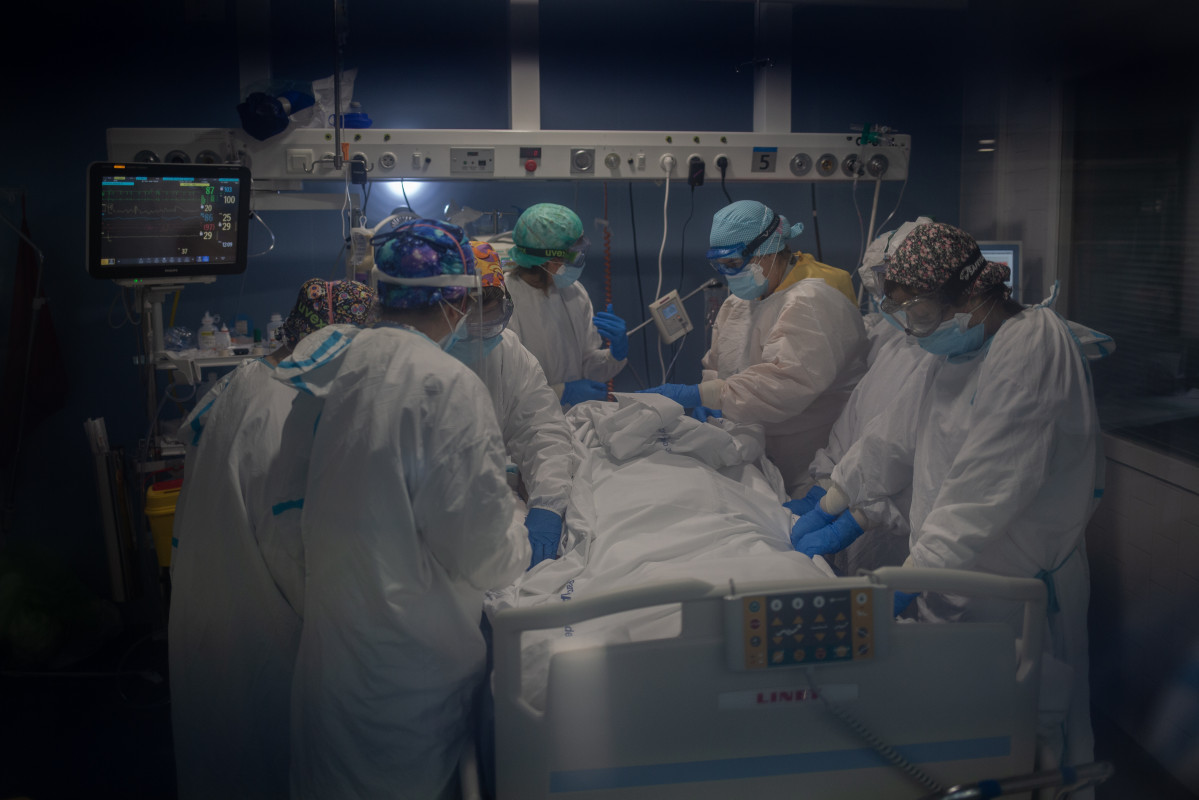 Archivo - Sanitarios atienden a un paciente en una UCI