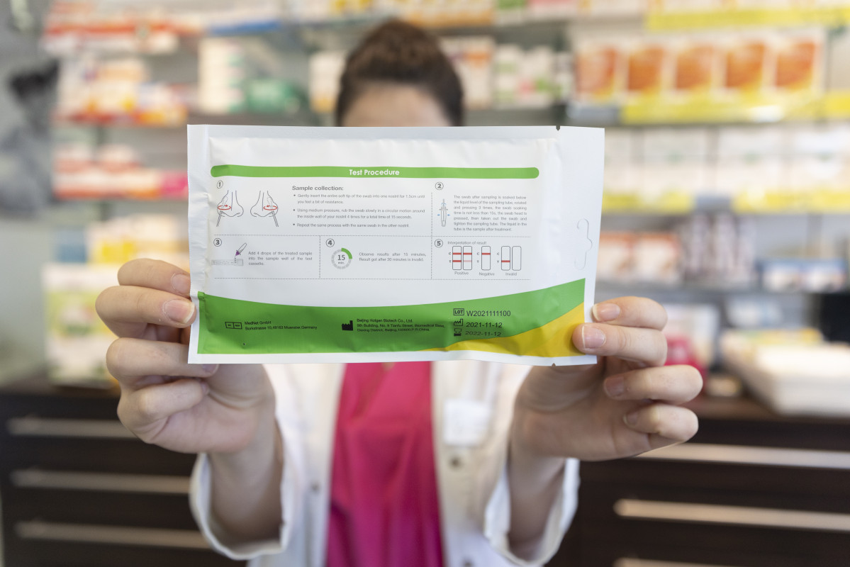 Una farmacèutica mostra un test d'antígens, foto d'arxiu