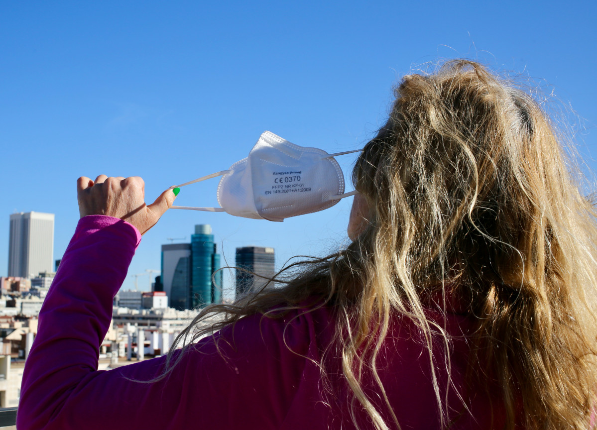 Una mujer se quita la mascarilla, a 8 de febrero de 2022, en Madrid (España).