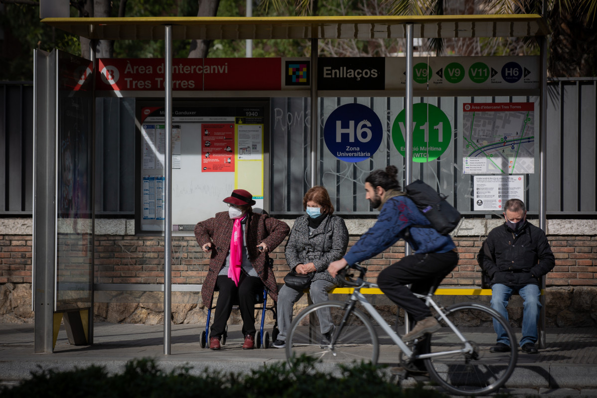 EuropaPress 4258052 persona bicicleta passa junt aturada on diverses persones esperen autobus