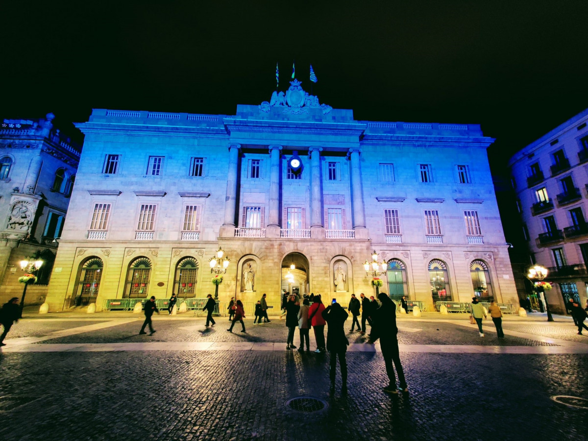 Façana de l'Ajuntament de Barcelona il·luminada amb el blau i el groc de la bandera d'Ucraïna.
