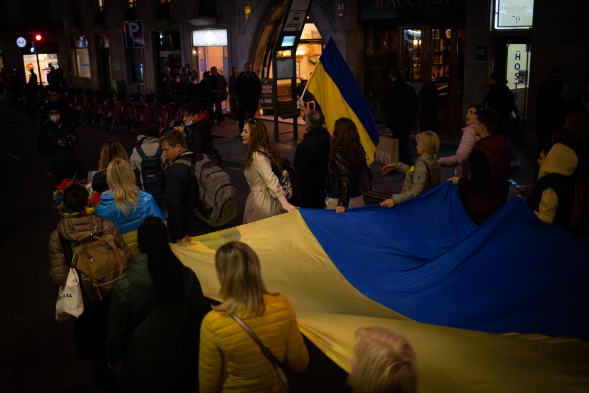 Un grup de persones sostenen la bandera d'Ucraïna en una concentració davant de l'ambaixada russa a Barcelona després dels primers atacs russos registrats a Ucraïna aquesta matinada, a 24 de febrer de 2022, a Barcelona, Catalunya (Espanya).