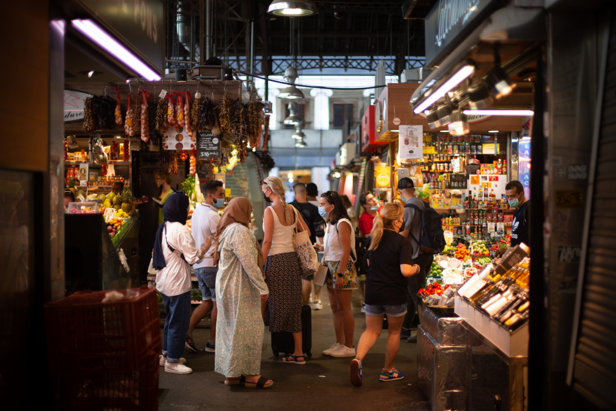 Archivo - Varias personas observan puestos de venta de comida en el mercado de La Boquería, a 5 de agosto de 2021, en Barcelona, Cataluña, (España).
