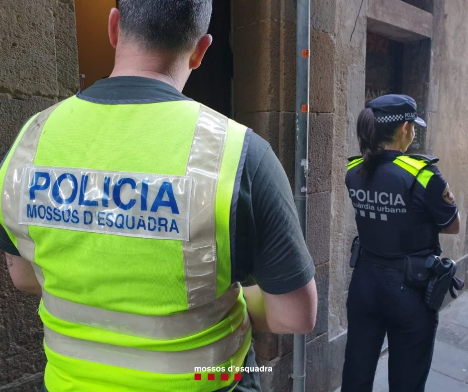Imagen de un agente de los Mossos d'Esquadra y una agente de la Guardia Urbana de Barcelona