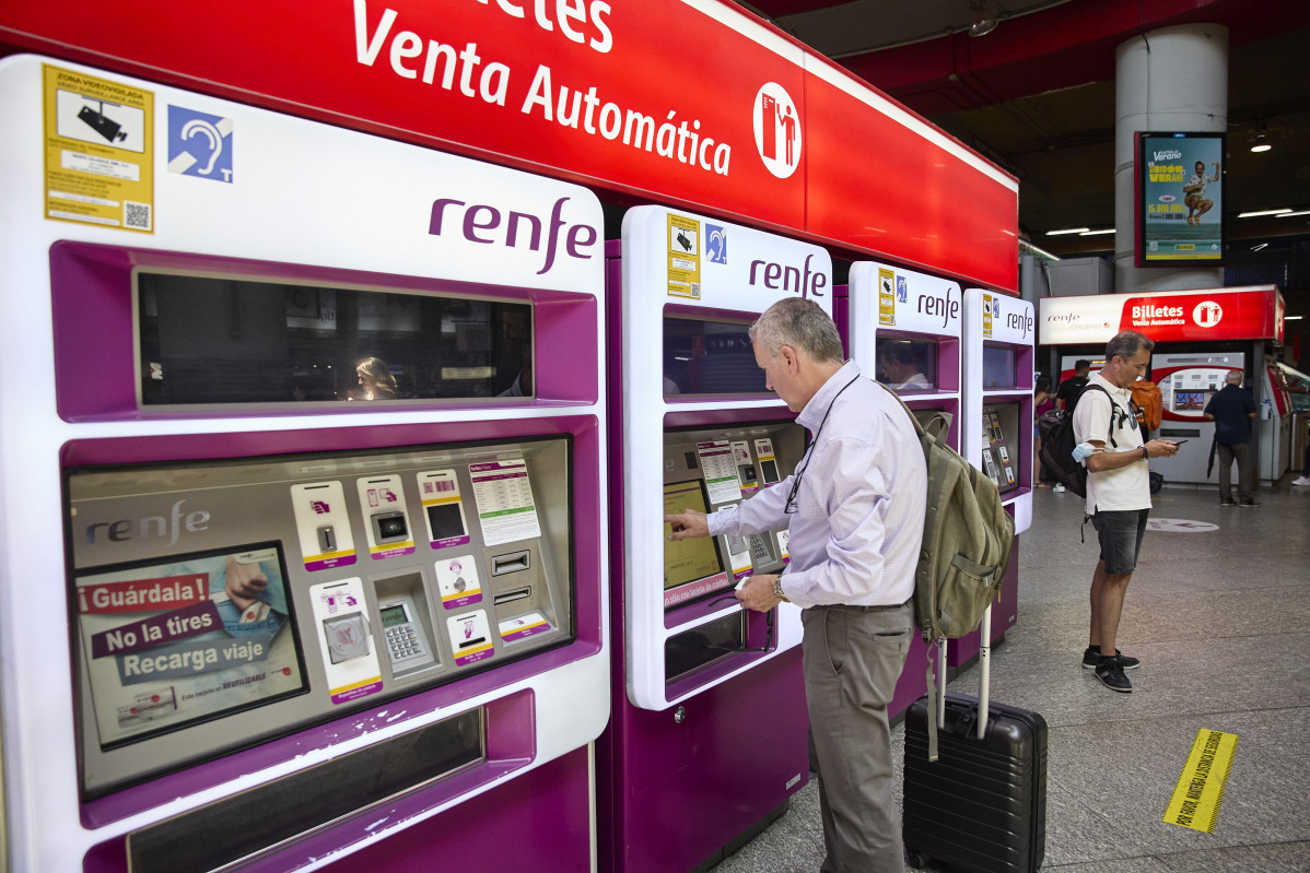 Una persona en una de les màquines de venda de bitllets a l'estació Madrid-Atocha Rodalies