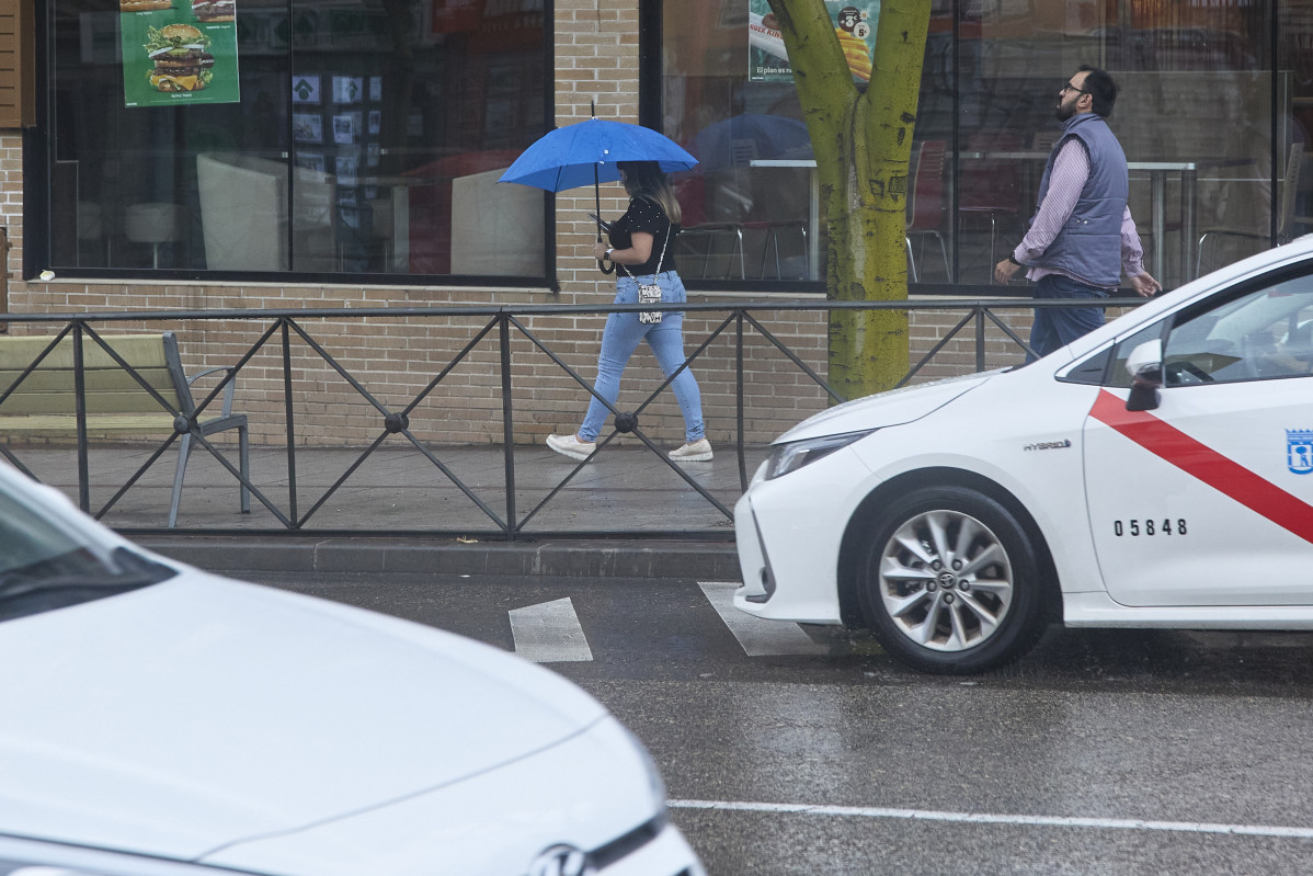 Una dona amb un paraigua passa pel carrer, el 15 de setembre del 2022, al districte de Carabanchel, a Madrid (Espanya). Les precipitacions produïdes per la borrasca 'Danielle' a la Comunitat de Madrid s'intensificaran avui dia conforme