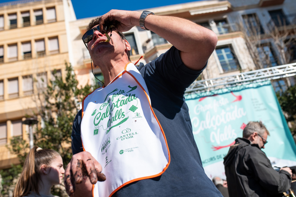 Adrià Wegrzyn es menja un calçot durant la festa de la Calçotada, a 29 de gener de 2023, a Tarragona, Catalunya