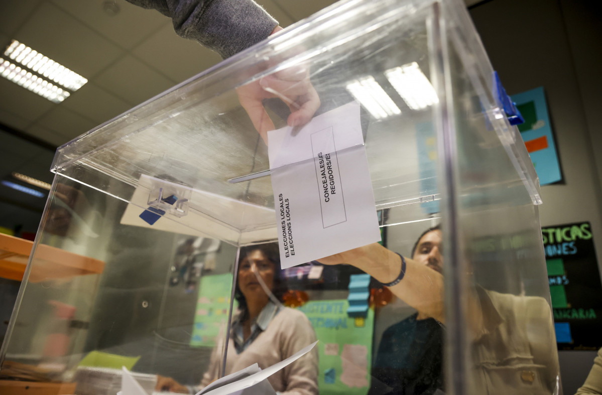 Una persona diposita el vot en una urna.
