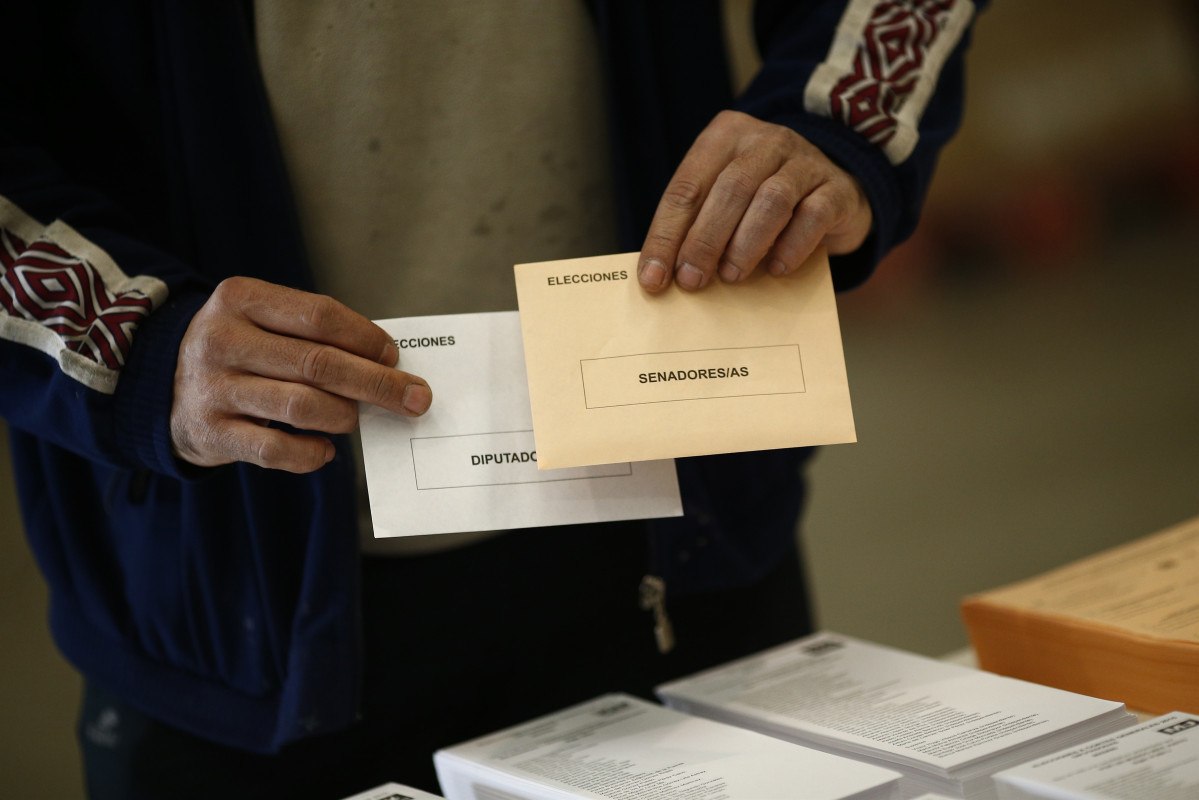 Arxiu - Un elector sosté els seus sobres de vortació per a les generals.
