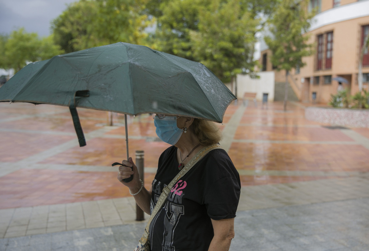 Arxiu - Una dona es protegeix de la pluja sota el seu paraigua