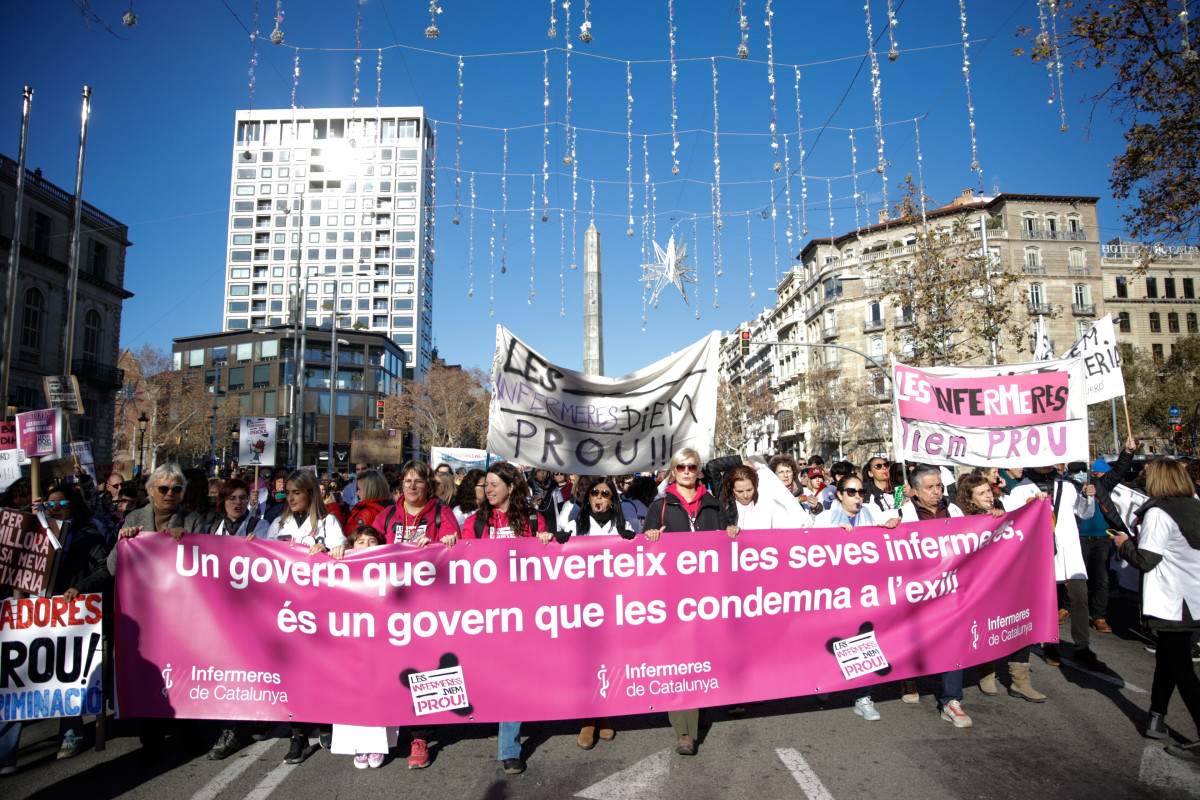Desenes de persones amb pancartes durant una manifestació d'Infermeres de Catalunya en la seva vaga indefinida, el 13 de gener del 2024, a Barcelona, Catalunya (Espanya). El sindicat 'Infermeres de Catalunya' continua en una vaga indefinida, que va començar