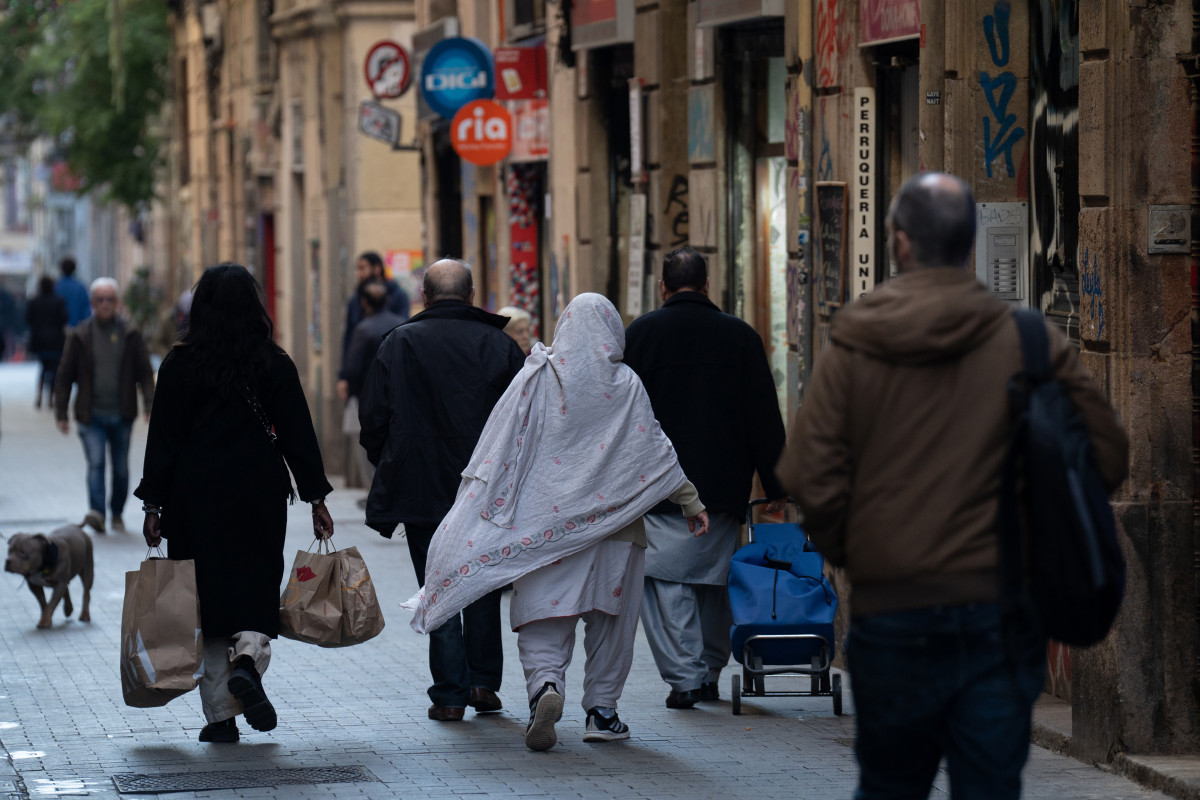 Diverses persones caminen carregades per un carrer, el 24 de gener del 2024, a Barcelona